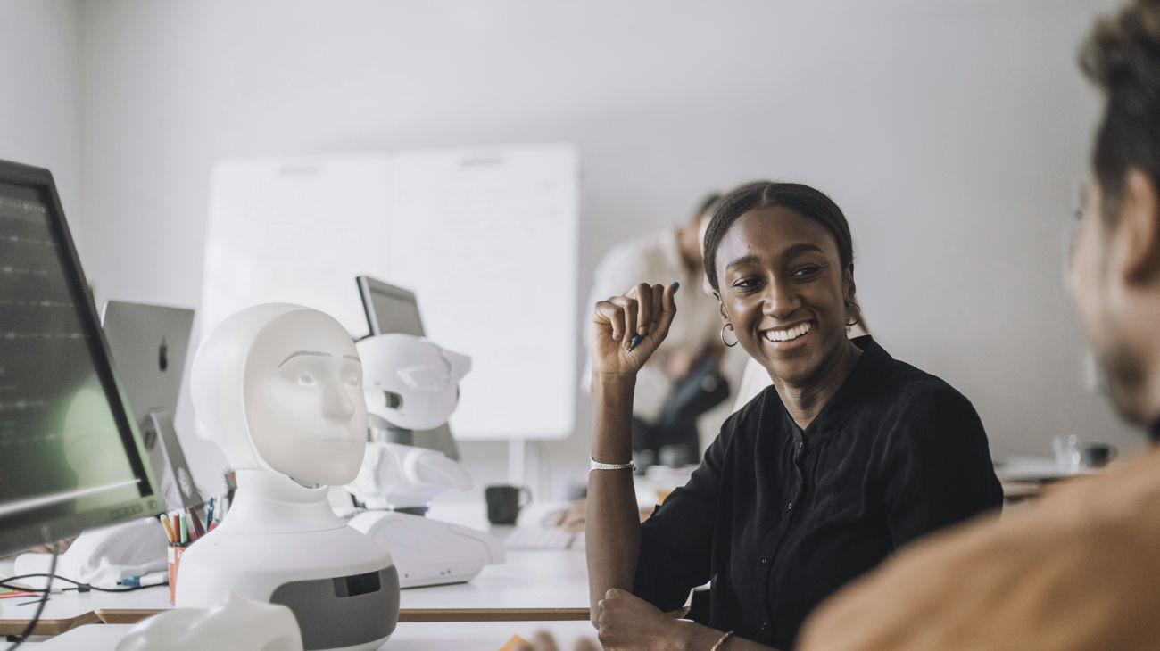 Kollegaer der snakker ved et skrivebord